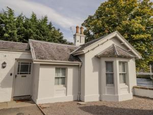 une petite maison blanche avec un garage dans l'établissement Porter's Lodge, à Inverness