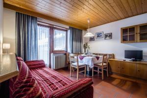 sala de estar con sofá y mesa de comedor en Residence A Val, en San Cassiano