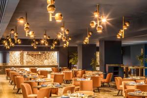 une salle à manger avec des tables, des chaises et des lustres dans l'établissement Pickalbatros Blu Spa Resort - Adults Friendly 16 Years Plus- Ultra All-Inclusive, à Hurghada