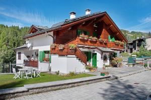 una casa con balcone e tavolo di Ginepro Casa Vacanze a Madesimo