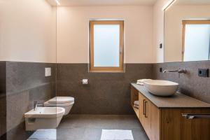 Un baño con lavabo, inodoro y espejo. en Hofer Hof Ziel, en Lagundo