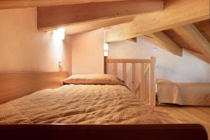 a large bed in a room with wooden ceilings at Casa Vacanza La Rocca Bilocale in Chiesa in Valmalenco