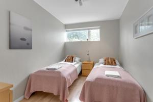 2 camas en una habitación con paredes blancas en Luxurious Private Villa, en Reikiavik