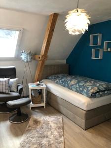a bedroom with a bed and a chair in a room at Charmante Ferienwohnungen auf Reitstall Wasserburg Anstel - ein Ort zum Wohlfühlen und Entspannen in Rommerskirchen