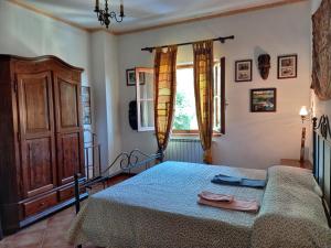 una camera con letto con copriletto blu e finestra di Casa Le Celle a Cortona