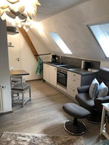 een keuken met een bank en een tafel in een kamer bij Charmante Ferienwohnungen auf Reitstall Wasserburg Anstel - ein Ort zum Wohlfühlen und Entspannen in Rommerskirchen