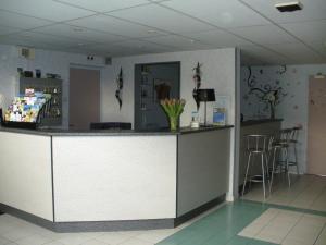 a lobby with a counter in a room with chairs at Relax Hotel in Maillat