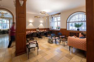 ein Restaurant mit Leuten, die an Tischen in einem Zimmer sitzen in der Unterkunft Hotel Minerva in Freiburg im Breisgau