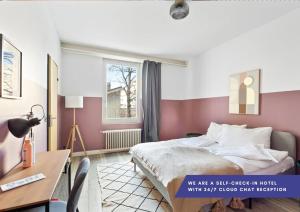 Schlafzimmer mit einem Bett, einem Schreibtisch und einem Fenster in der Unterkunft Becozy Self Check-in Hotel Basel an der Messe in Basel
