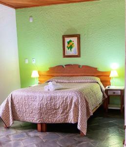 sypialnia z łóżkiem w zielonej ścianie w obiekcie Pousada Green Valley w mieście São Roque