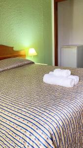 um quarto de hotel com uma cama com toalhas em Pousada Green Valley em São Roque