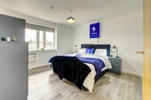 um quarto com uma cama com um sinal azul na parede em Spacious - PENTHOUSE 2 Bed Apartment with secure allocated parking em Sheffield