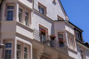 - un bâtiment blanc avec des fleurs sur les balcons dans l'établissement Hotel Minerva, à Fribourg-en-Brisgau