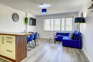 a living room with a blue couch and a table at Spacious - PENTHOUSE 2 Bed Apartment with secure allocated parking in Sheffield