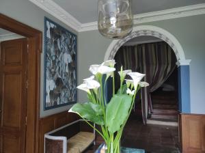 un vase avec des fleurs blanches dans une pièce dans l'établissement Domaine de Cremens, 