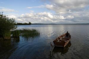 un barco de madera sentado en medio de un lago en TL083 - 2 Bedrooms indoor pool Loch Views fishing Golf Riding Shooting Water Sports 15 min drive to beaches PASSES NOT INCLUDED Most Activities Will Not Be Available Out Of Season Please Check Before Booking en Newton Stewart