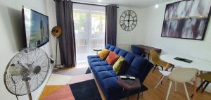 a living room with a blue couch and a table at Garland Modern Central City Apartment London in London