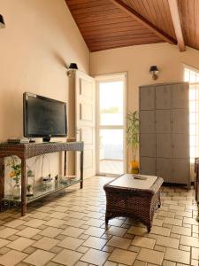 a living room with a flat screen tv and a table at Pousada do Luar Cabo Frio in Cabo Frio
