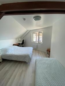 a bedroom with two beds and a wooden floor at Maison Individuelle avec jardin privatif in Avon