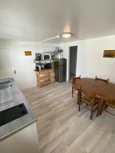 a living room with a table and a kitchen at Maison Individuelle avec jardin privatif in Avon