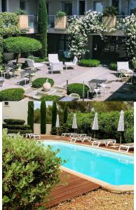 a pool with chairs and tables and umbrellas at Patio De Violette in Uzès