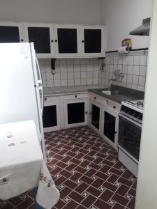 a kitchen with white cabinets and a tile floor at Villa Lidia in Mar del Plata