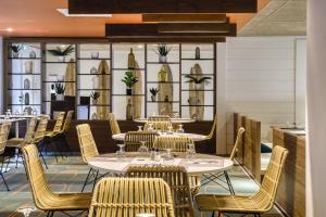 a dining room with tables and chairs and windows at Belambra Clubs Anglet - La Chambre d'Amour in Anglet