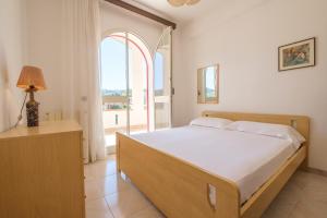 - une chambre avec un lit et une grande fenêtre dans l'établissement Villa Delle Pomelie, à Torre Forte