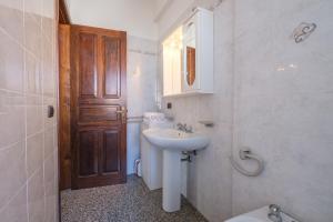 La salle de bains est pourvue d'un lavabo, de toilettes et d'une porte. dans l'établissement Villa Delle Pomelie, à Torre Forte