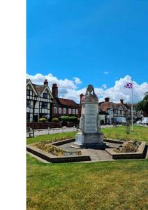a monument in a park with a building in the background at Manor Green Cottage in Windsor