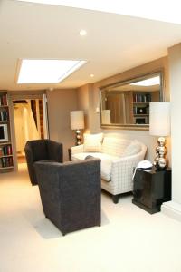 a living room with a couch and a mirror at Manor Green Cottage in Windsor