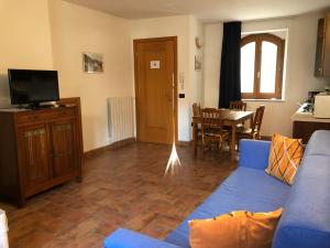a living room with a blue couch and a table at Casa Mary apartments in Tignale