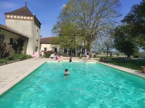 a person in a swimming pool in a yard at Domaine de Cremens 