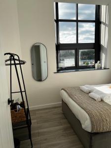 Spire Accommodations Ltd في برادفورد: غرفة نوم مع سرير ومرآة على الحائط