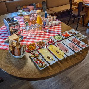 una mesa con muchos tipos diferentes de comida en ella en Boutique-Hotel Zum Grünen Baum, en Alzenau