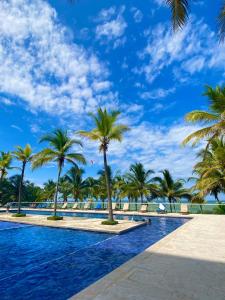 einen Pool mit Palmen und blauem Himmel in der Unterkunft Hermoso apartamento en la playa in Cartagena de Indias