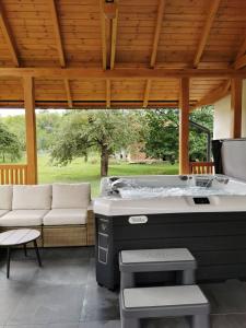 a jacuzzi tub in a pavilion with a couch at CsakTi Vendégház in Szilvásvárad