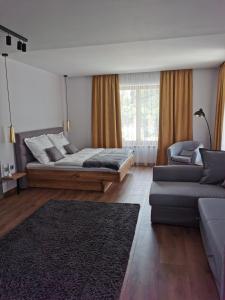 sala de estar con 2 camas y sofá en CsakTi Vendégház, en Szilvásvárad