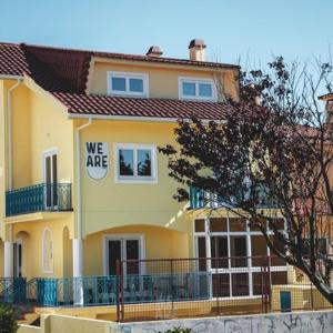 a yellow house with a sign that says we are at WE ARE HOSTEL in Póvoa de Varzim