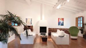 - un salon avec un canapé blanc et un fauteuil vert dans l'établissement LUXURY 270M² HOUSE OF CHARACTER IN OLD STONES WITH HEATED POOL, NEAR CALVI, à Calenzana