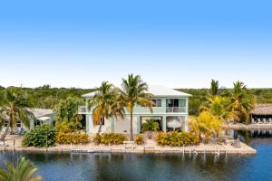 une maison sur l'eau avec des palmiers dans l'établissement Sunset Villa, à Big Pine Key