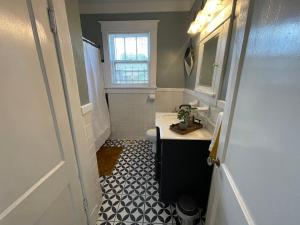 baño con lavabo y aseo y ventana en Historic Revival 2BR Midtown Memphis Fast Wifi Free Parking Yes Pets, en Memphis