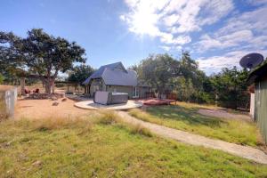 un patio con una casa con un sofá en el césped en Twilight Ranch - 6 acre ranch w/hot tub and dog friendly!, en Luckenbach