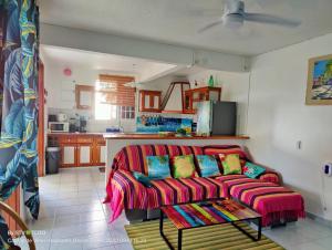 sala de estar con sofá rojo y almohadas coloridas en Luketo en Vieux-Habitants