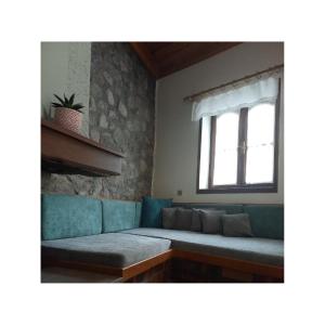 a living room with a couch and a window at Potamolithos Suites in Konitsa