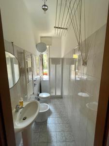 a white bathroom with two toilets and a sink at Claudia's Home in FieraCity&MiCo&SanSiro in Milan
