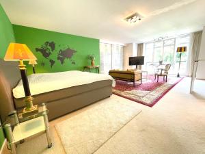 a bedroom with a bed and a green wall at Doppelzimmer Gartenblick Villa Julian in Aurich