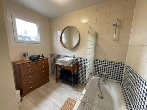 een badkamer met een bad, een wastafel en een spiegel bij le Cottage de la Plage - Maison avec garage in Mers-les-Bains