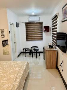een slaapkamer met een bed, een tafel en stoelen bij Paris Unit Tagaytay Netflix/Wifi/Parking in Tagaytay