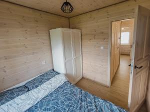 um quarto com uma cama num quarto de madeira em Szary Domek w Karkonoszach em Podgórzyn